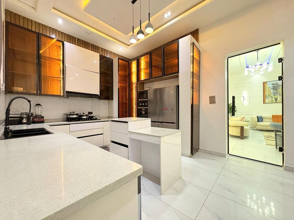 Short-let apartment kitchen with a restrained white and wood palette